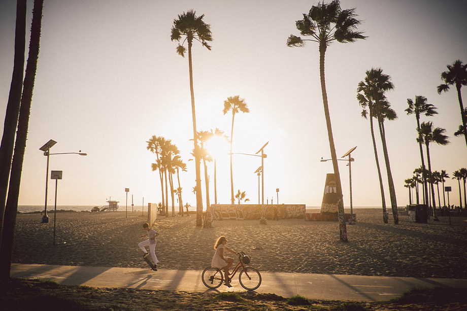 Biker and skateboarder in Venice Beach, Los Angeles, California at sunset